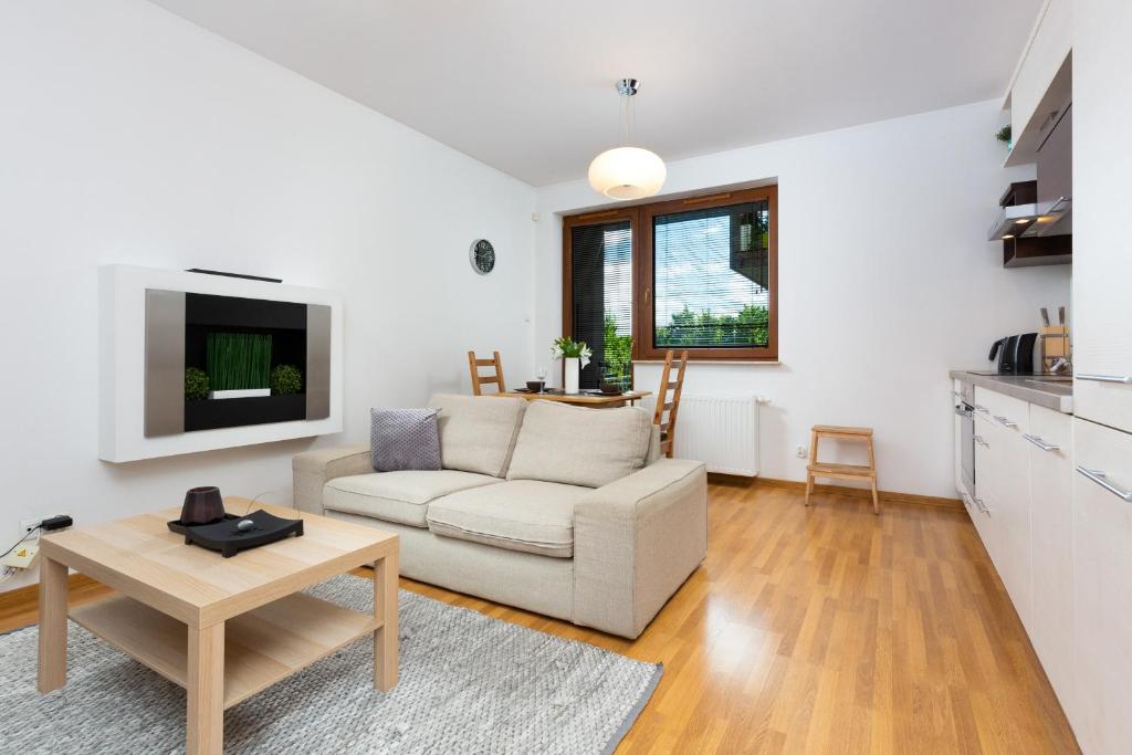 a living room with a couch and a table at Apartments Platynowa Gdańsk by Renters in Gdańsk