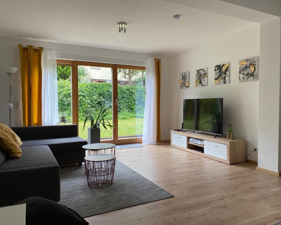 a living room with a couch and a flat screen tv at Fuchsbau-Goldbach in Goldbach