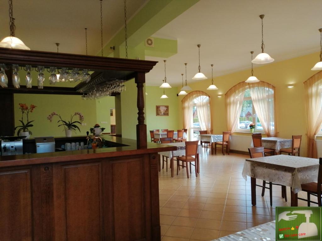 restauracja z barem, stołami i krzesłami w obiekcie Villa Sylvia w Dźwirzynie