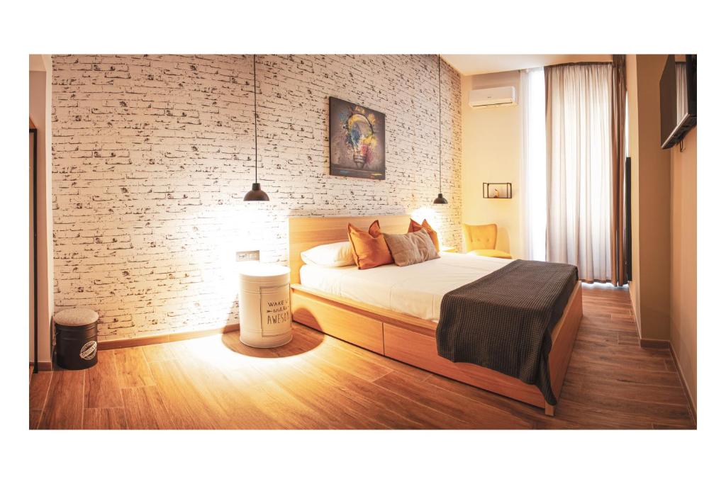 um quarto com uma cama e uma parede de tijolos em Industrial House Napoli em Nápoles