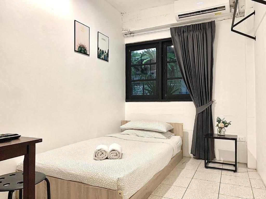 a bedroom with a bed with two towels on it at Gfeel Hostel in Bangkok
