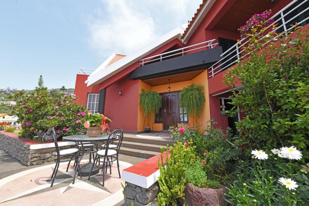 a patio with a table and chairs in front of a house at Ponta do Sol Villa in Ponta do Sol