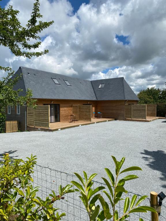 a house with a large driveway in front of it at Les Apparts in Genneville