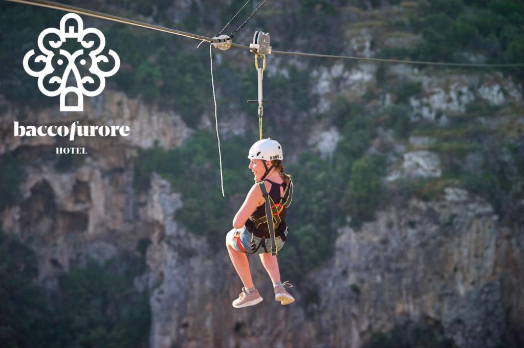 a person on a zip line over a mountain at Albergo Diffuso Bacco Furore in Furore