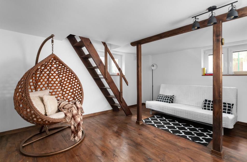 Masuria Warsaw - dom na wyłączność - w lesie i przy rzece - 15 min od Warszawy في Skrzeszew: غرفة بها كرسي معلق وأريكة