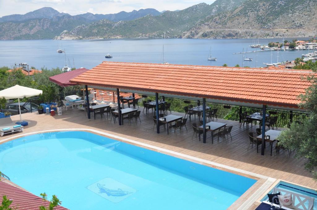 a resort with a swimming pool and a view of the water at Lacivert Boutique Hotel in Selimiye