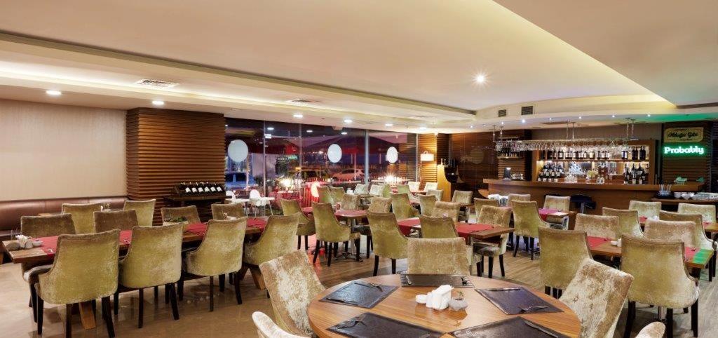 a restaurant with tables and chairs and a bar at Anemon Cigli Hotel in İzmir