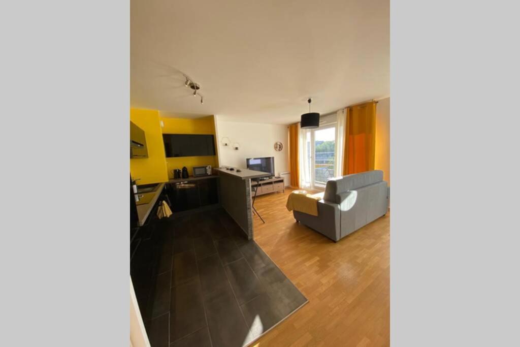 un salon avec un canapé et une table dans l'établissement Cosy and Quiet flat close to Disneyland Paris, à Montévrain