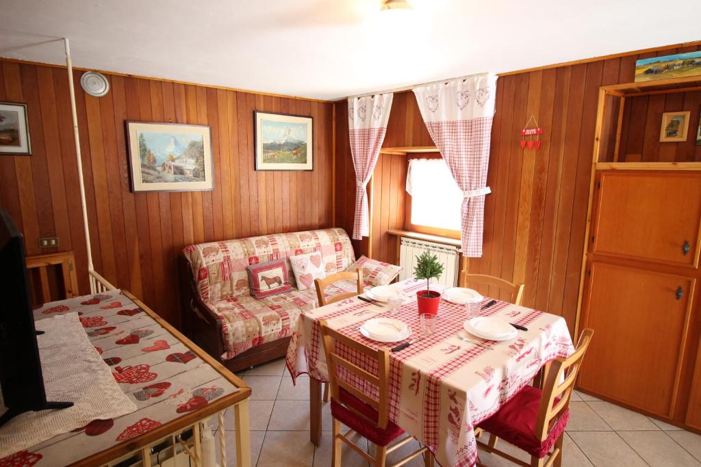 uma sala de estar com uma mesa e um sofá em Lo Stambecco Holiday Apartment - Affitti Brevi Italia em Brusson