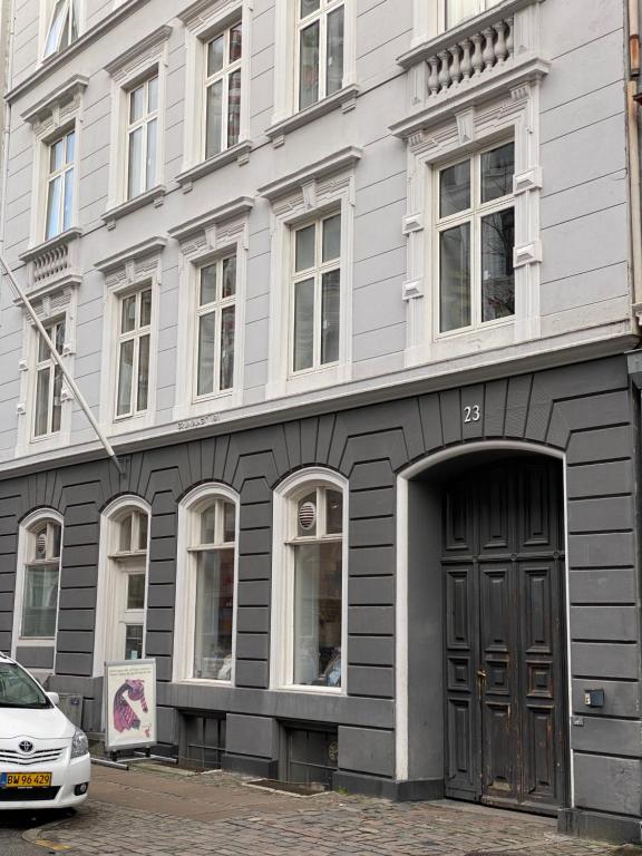 um edifício com uma porta e um carro estacionado em frente em PSG 23 - Short Stay Apartments by Living Suites em Copenhague