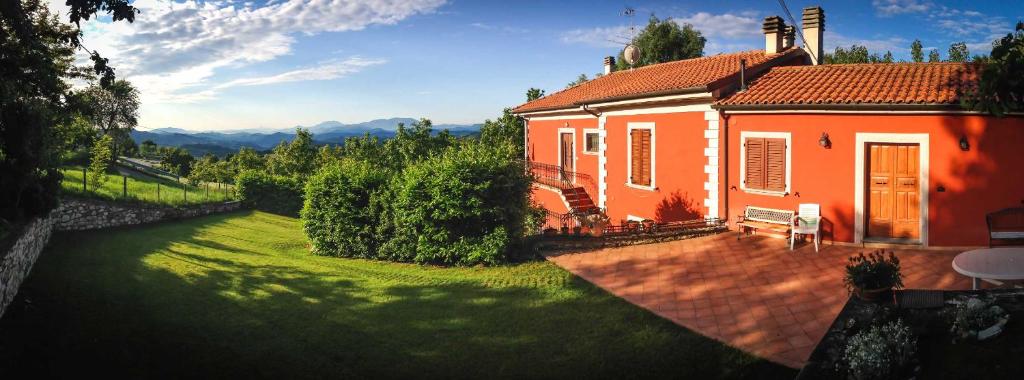 una pequeña casa naranja con un patio verde en B&B il Bughetto, en Carpegna