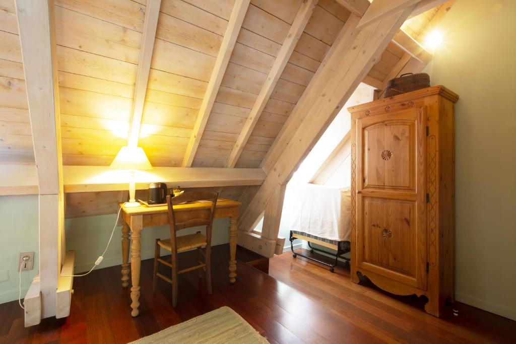 a room with a table and a lamp in a attic at Les gerbes in Arras-en-Lavedan