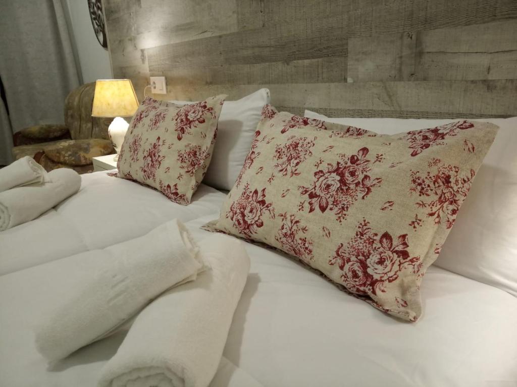a white bed with red and white pillows on it at Alojamientos rurales La Barca del tío Vito in Peloche