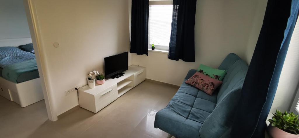 a small living room with a couch and a television at Apartment MINT in Senec