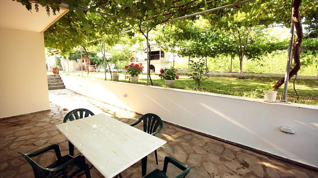 a white table and chairs and a table and a window at Villa Valeria Thassos in Limenas