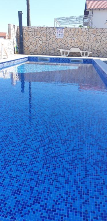 a swimming pool with blue tiles on the water at Apartments Slavica Trogir in Trogir