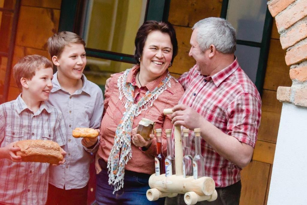 a woman and two boys are standing next to a man at Biohof Grissenberger in Abetzdorf