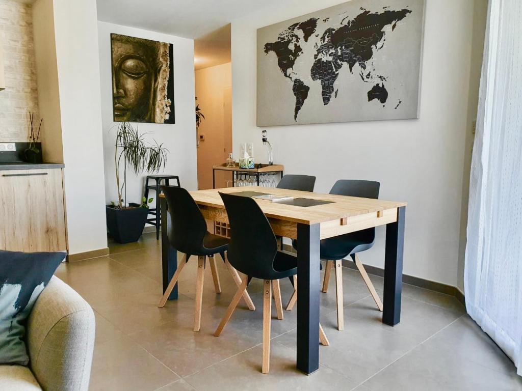 une table à manger avec des chaises et une carte du monde sur le mur dans l'établissement Le petit marquisat à deux pas du lac, à Annecy