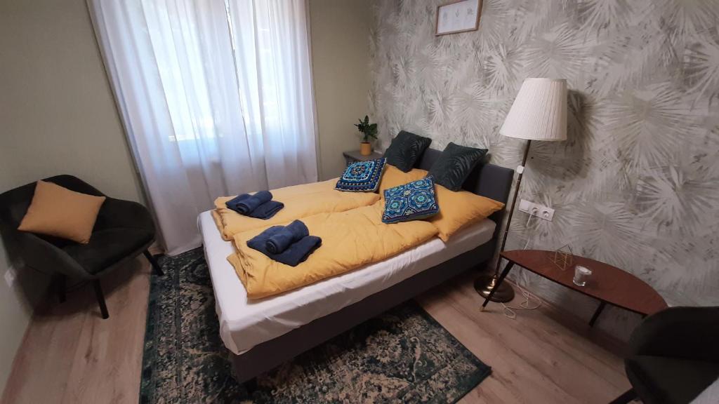 a bedroom with a bed with blue pillows at MHC Apartman in Kaposvár