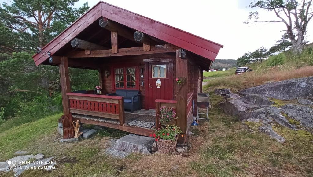 a small red shed sitting on top of a hill at Suigard Smia in Sauland