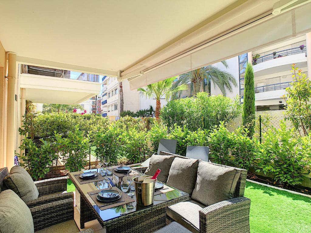 a patio with a couch and a table at Palm Beach apartment with a pool in the residence in Cannes