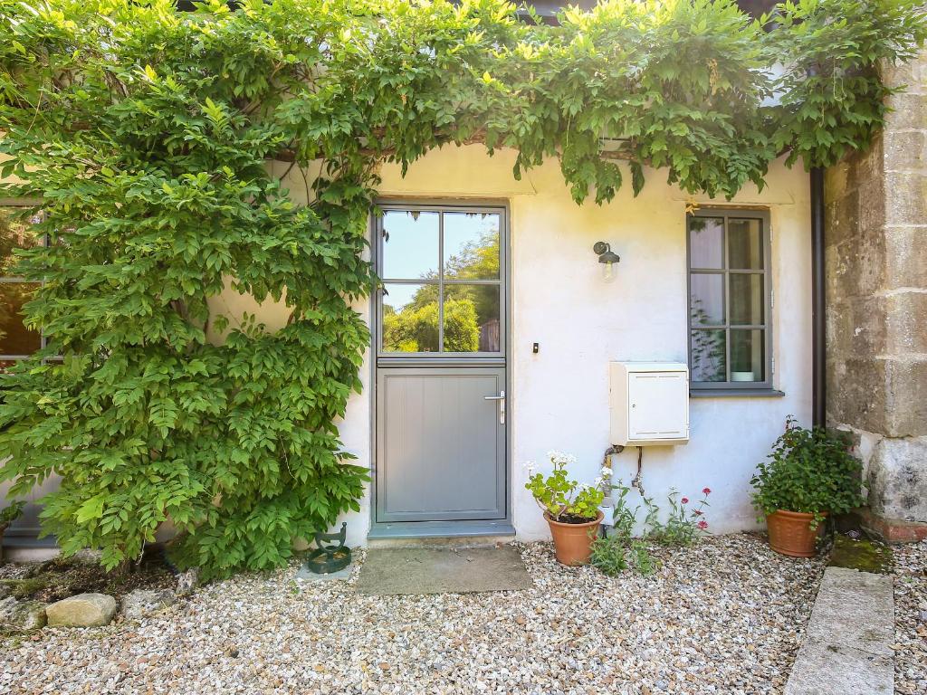 a front door of a house with a tree at Kings Cottage - South in Broad Chalke