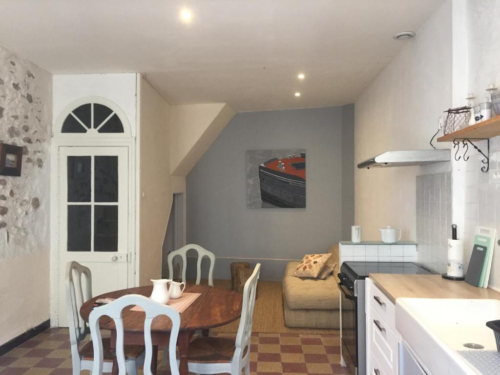 a kitchen and living room with a table and chairs at Le Petit Relais du Canal in Trèbes