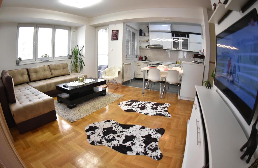 ein Wohnzimmer mit einem Sofa und einer Küche in der Unterkunft Modern & Cozy in Skopje