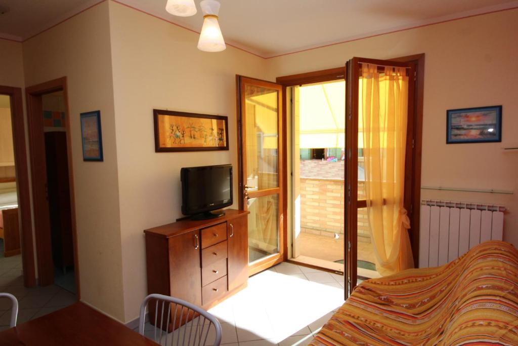 羅索利納馬雷的住宿－Residence Sole e Mare appartamenti，客房设有电视、床和窗户。