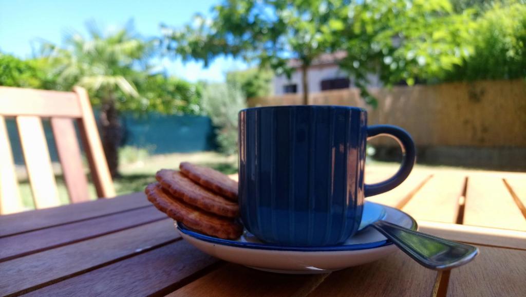 a blue coffee cup sitting on a table with sausages at Fleurs de Cosmos in Albi