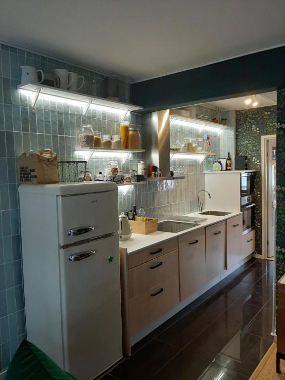 uma cozinha com um frigorífico branco e um lavatório em Alice Apartment - main street em Rovaniemi