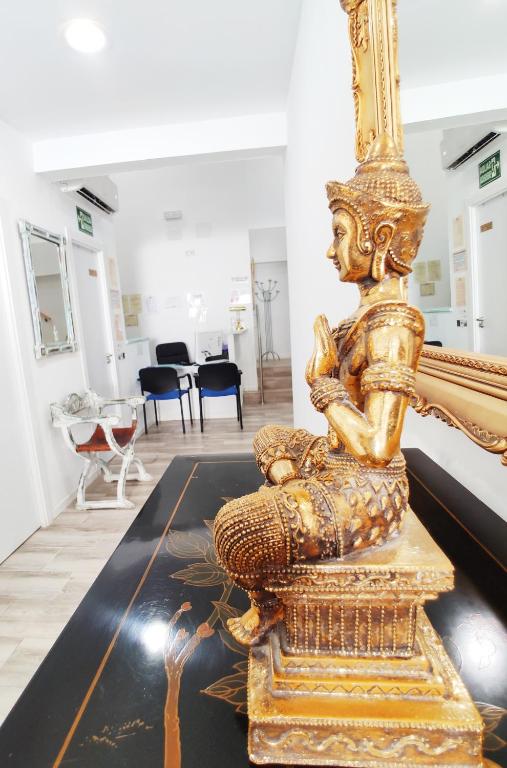 a gold statue of a woman sitting on a table at Palafox 23 in Madrid