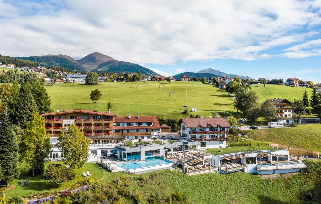 eine Luftansicht eines Resorts mit Bergen im Hintergrund in der Unterkunft Parkhotel Holzerhof in Meransen