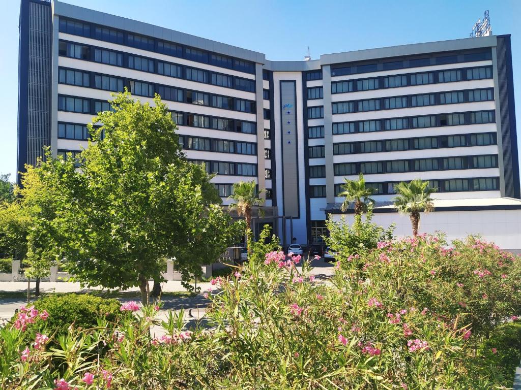 un immeuble de bureaux avec des fleurs devant lui dans l'établissement Buyuk Saruhan Hotel, à Manisa