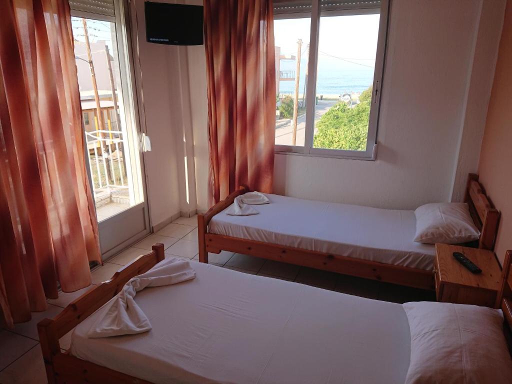 two beds in a room with a view of the ocean at House Papus in Sarti