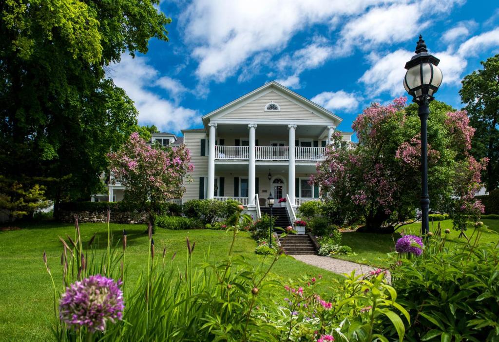 una casa blanca con un patio con flores en Harbour View Inn, en Mackinac Island