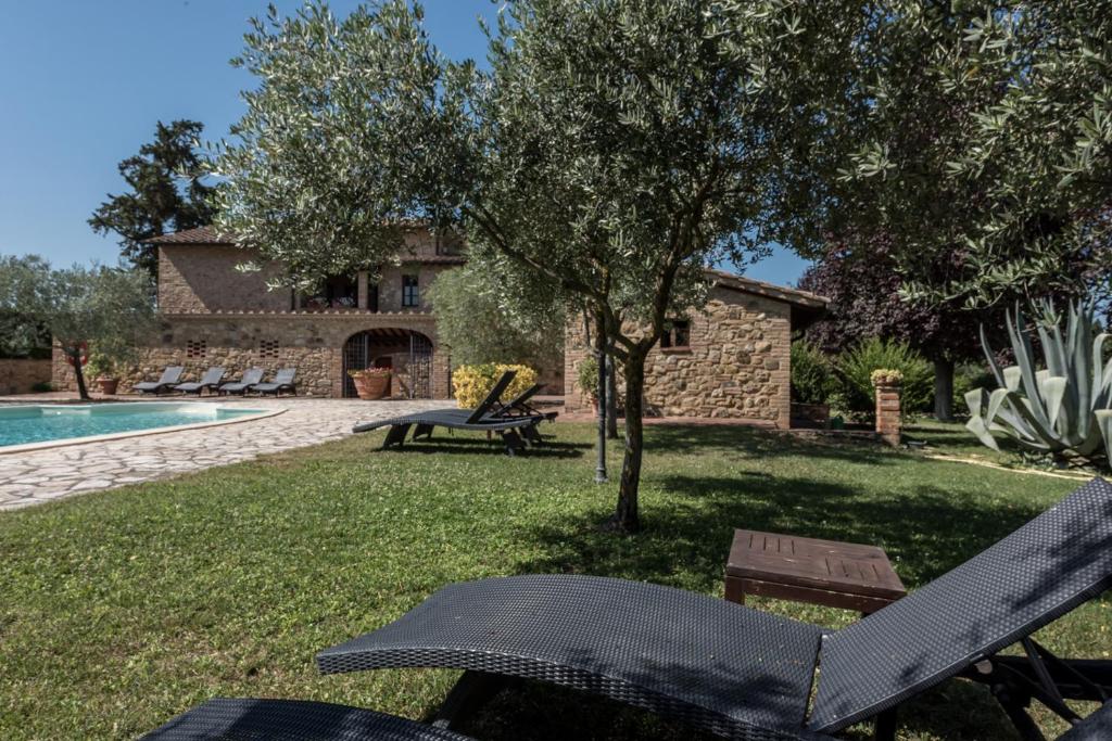 a backyard with a swimming pool and a house at I Melograni del Chianti in Poggibonsi
