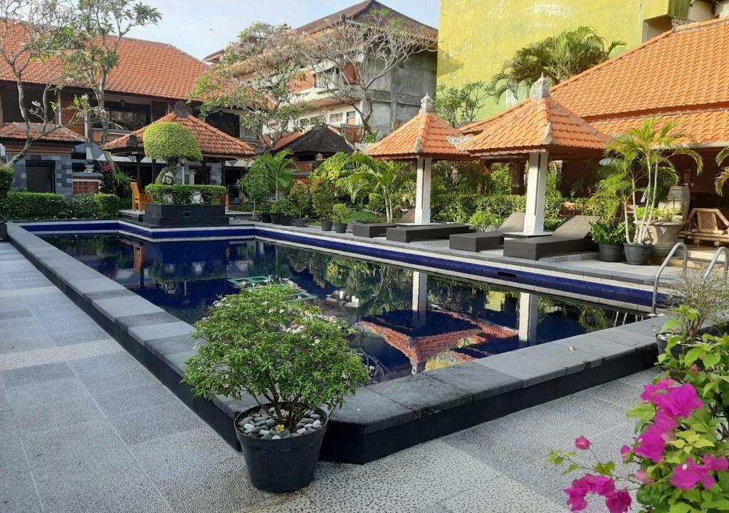 a pool in the middle of a building with plants at Dewa Bharata Bungalows Legian in Legian