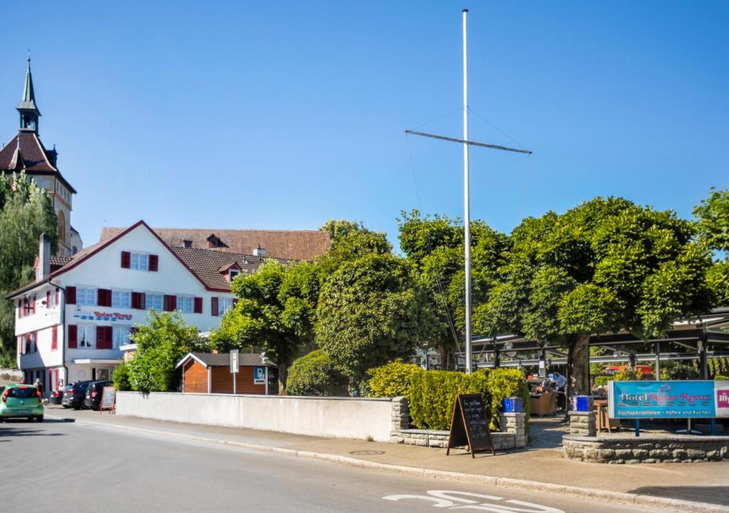 een straat in een stad met een gebouw en bomen bij Hotel Rotes Kreuz in Arbon