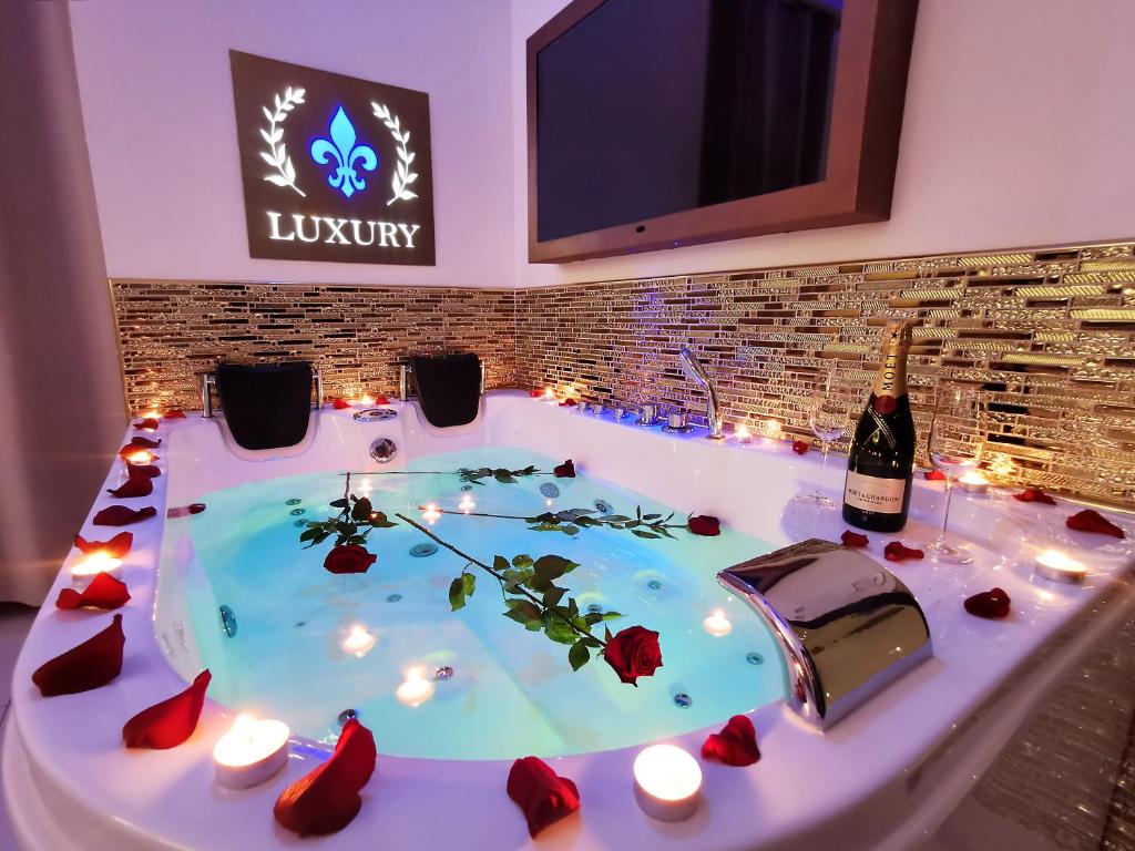 una vasca idromassaggio con candele e una bottiglia di vino di Giglio Luxury Apartment - Chroma Italy a Roma