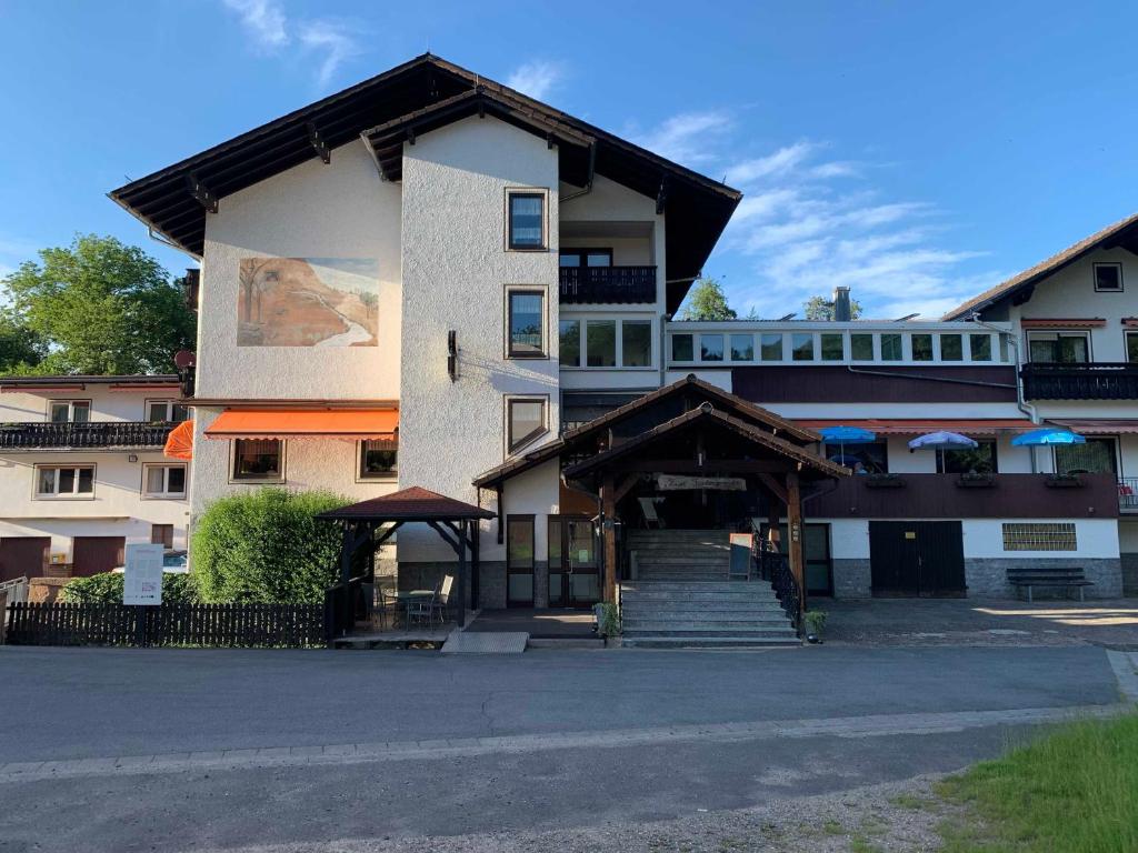 a large building with a staircase in front of it at Gasthaus & Pension Zum Fürstengrund in Reichelsheim