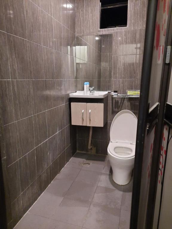 a bathroom with a toilet and a sink at Hotel Cipta Impian in Kampong Keriting