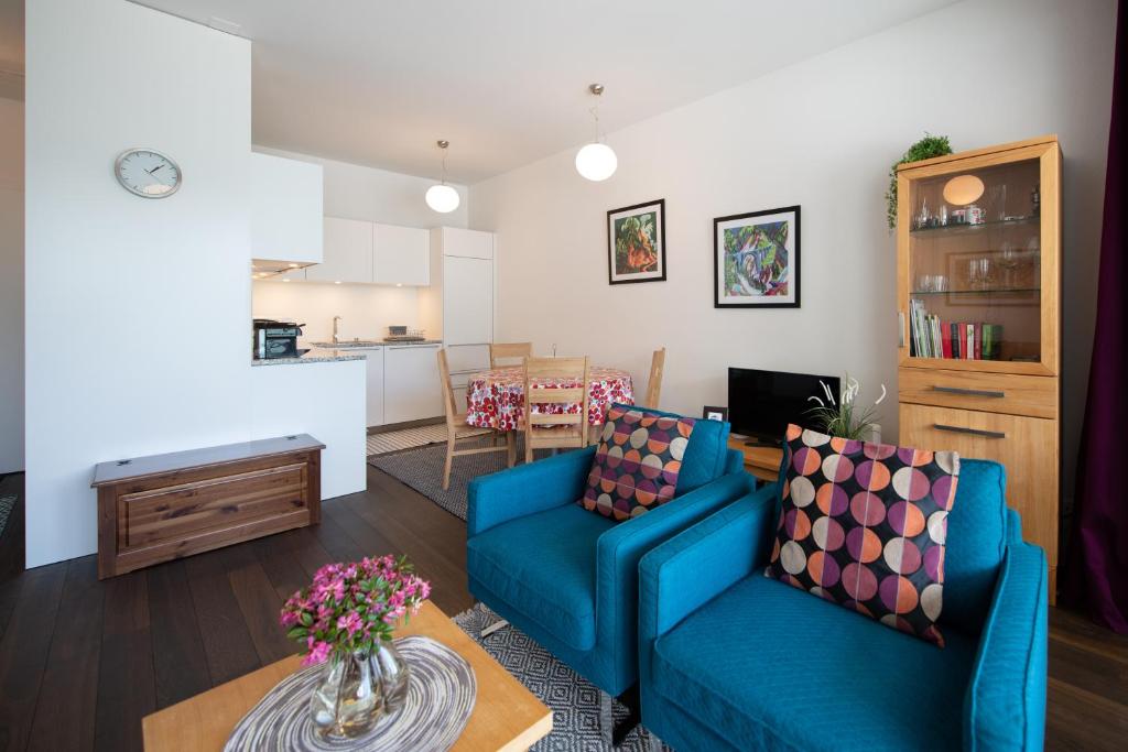 達沃斯的住宿－Centralhof A 22，客厅配有2张蓝色的沙发和1张桌子