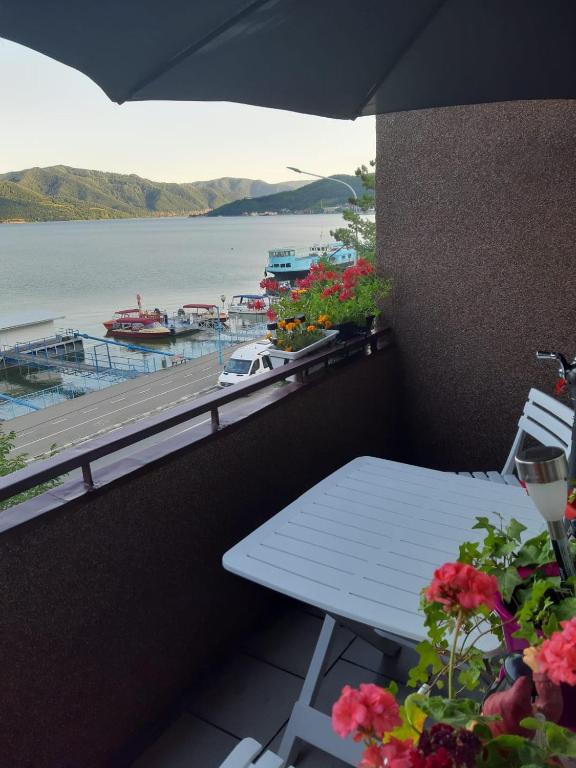a table on a balcony with a view of a marina at Apartament Edy in Orşova