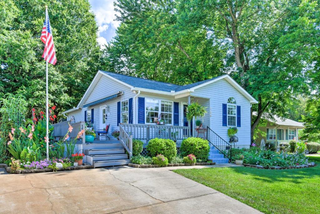 una casa azul con una bandera delante de ella en Lake Norman Home with Porch - Across from Marina!, en Mooresville