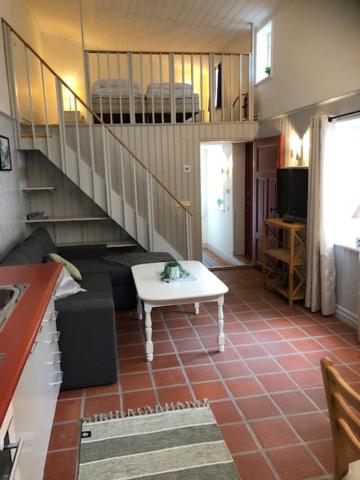 a living room with a staircase and a table at Gårdshuset in Söderköping