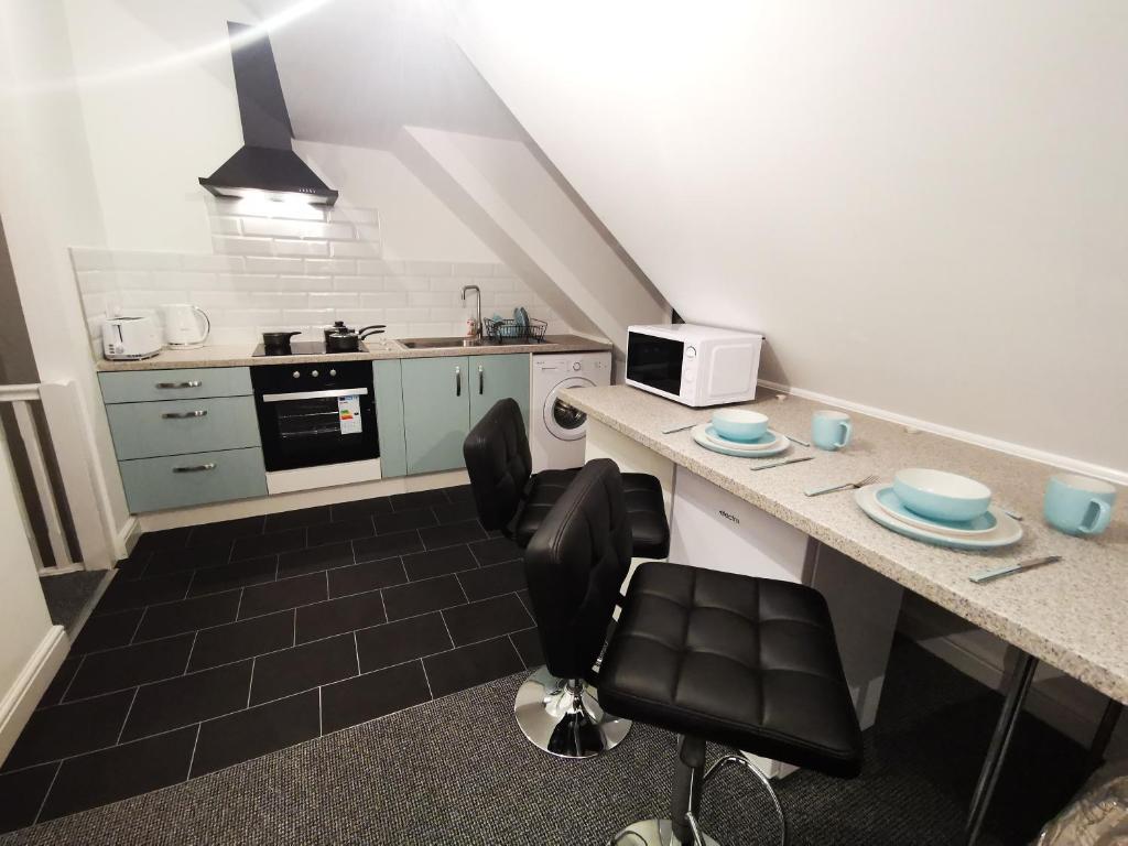 a small kitchen with a counter and a chair at Highview House Redcar-Seaview Apartments in Redcar