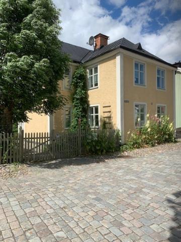 una casa grande con una valla delante en Grindhuset, en Söderköping