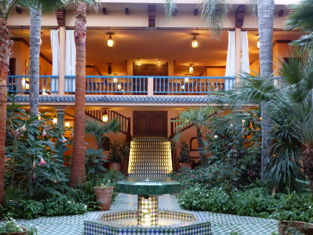 arium of a hotel with palm trees and a fountain at La Villa Mandarine in Rabat