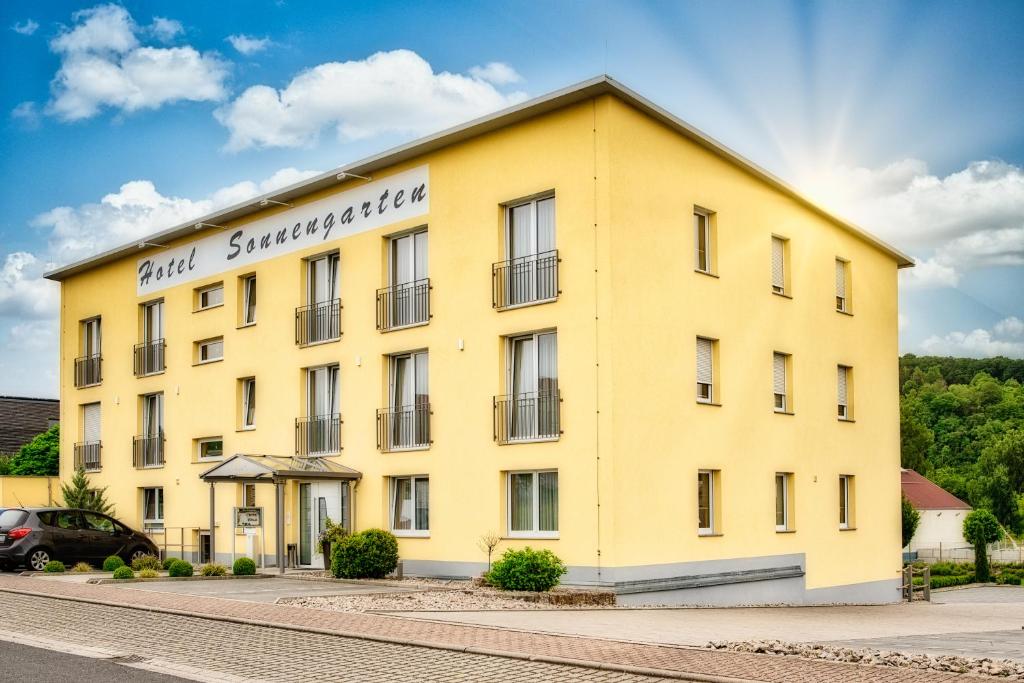 ein gelbes Gebäude mit einem Schild darauf in der Unterkunft Hotel Sonnengarten in Sommerhausen